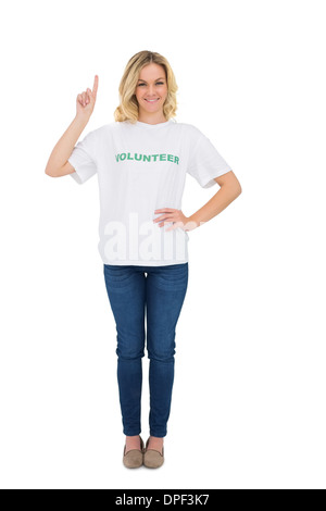 Cheerful blonde volunteer pointant vers le haut Banque D'Images