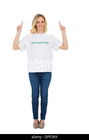 Smiling blonde volunteer pointant vers le haut Banque D'Images