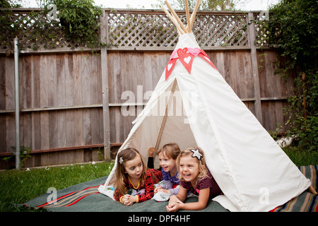 Trois jeunes filles se trouvant dans la région de tipi dans le jardin Banque D'Images