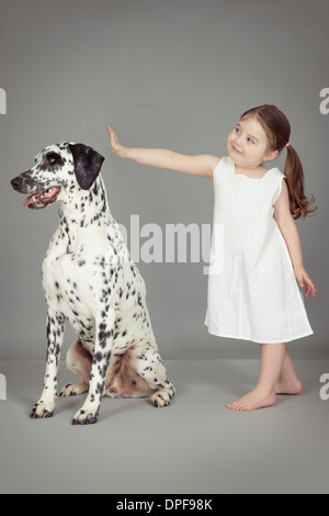 Studio portrait of female toddler et chien dalmatien Banque D'Images