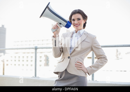 Charmante brune élégante businesswoman holding a megaphone Banque D'Images