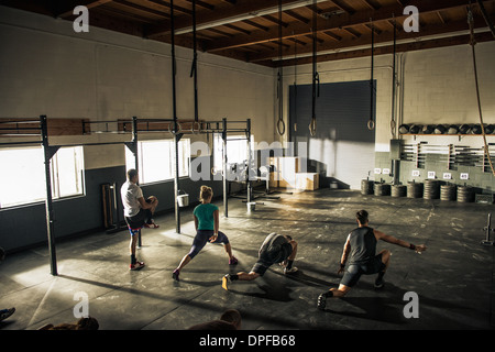 Cours de conditionnement physique l'échauffement ensemble dans une salle de sport Banque D'Images