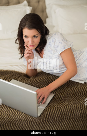 Assez pacifique brown haired woman using a laptop Banque D'Images