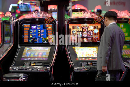 Düsseldorf, Allemagne. 14Th Jan, 2014. Les visiteurs regarder les machines à à la foire commerciale internationale pour l'Amusement et des distributeurs automatiques dans l'IMA Duesseldorf, Allemagne, le 14 janvier 2014. Aujourd'hui la direction générale examine la situation actuelle du marché du jeu. Photo : Federico Gambarini/dpa/Alamy Live News Banque D'Images