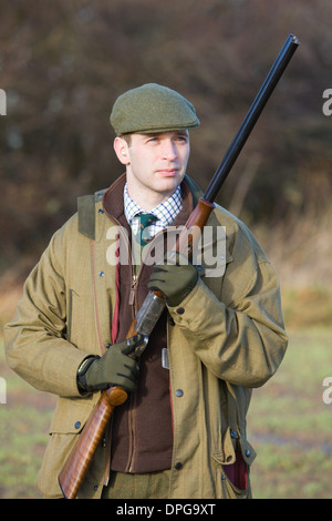 Un homme avec un fusil sur un faisan tourner en Angleterre Banque D'Images