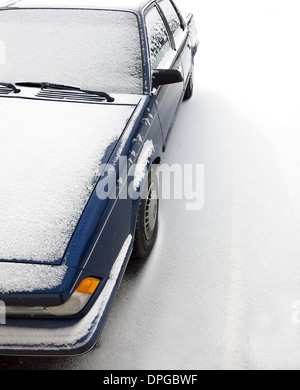 Voiture garée sur la rue couverte de neige pendant l'hiver Banque D'Images