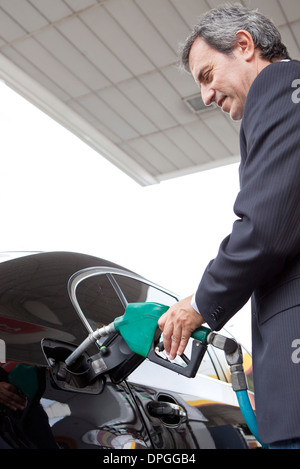 Businessman refueling car at gas station Banque D'Images