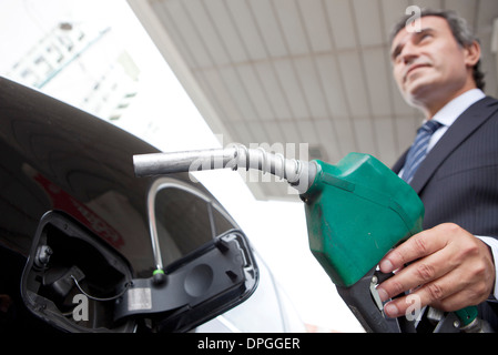 Businessman refueling car at gas station Banque D'Images