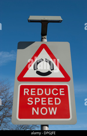 La signalisation routière indiquant un rond-point de l'avant et à réduire la vitesse maintenant Banque D'Images