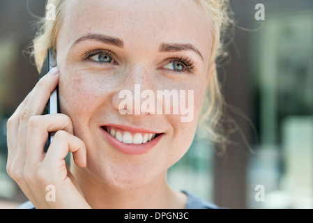 Jeune femme faisant appel à l'aide téléphone intelligent Banque D'Images