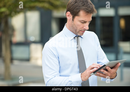 Businessman using digital tablet outdoors Banque D'Images