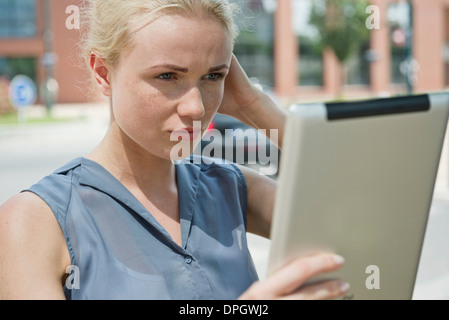 Young woman using digital tablet pour prendre une photo Banque D'Images