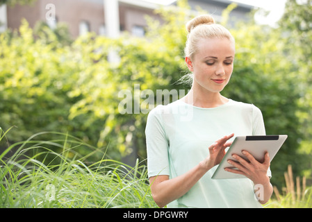 Young woman using digital tablet outdoors Banque D'Images