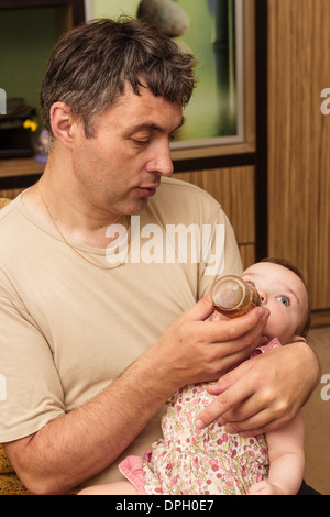 L'homme nourrit le bébé. Banque D'Images