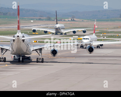 Trois avions de passagers dans le trafic lourd sur la voie de circulation de l'aéroport international de Zurich. Types d'aéronefs sur l'image : Banque D'Images