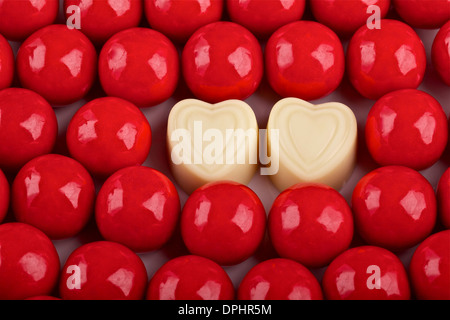 Bonbons rouges et deux coeurs de chocolat blanc ,Valentine's Day background Banque D'Images