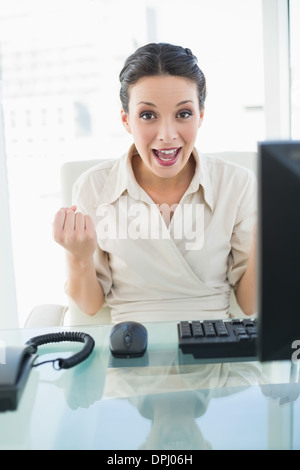 Élégante brunette woman joyeux élever ses poings Banque D'Images
