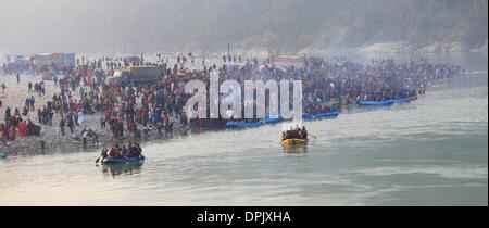 Tanahu, au Népal. 15 Jan, 2014. Les dévots hindous népalais se rassemblent à la confluence de la Trishuli et Narayani rivers pendant Maghe Sankranti Festival à Devghat à Tanahu district, le Népal, le 15 janvier 2014. Maghe Sankranti est un des festivals importants au Népal, et est surtout marquée par les Hindous népalais en prenant un bain rituel dans la confluence des rivières et offrant des cultes dans divers temples, et de manger des plats spéciaux comme chaku durci (mélasse), til ko laddu (sucreries) et sésame tarul (igname). Credit : Sunil Sharma/Xinhua/Alamy Live News Banque D'Images