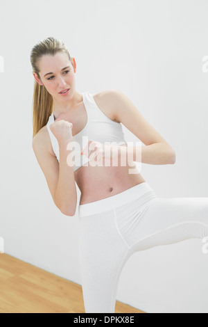 Jeune femme concentrée dans les vêtements de sport arts martiaux faisant Banque D'Images