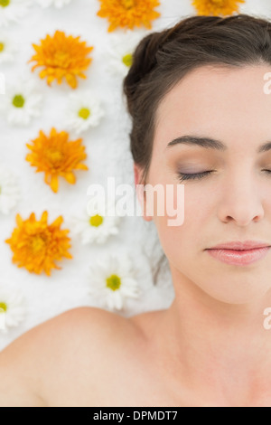 Belle jeune femme avec les yeux fermés et fleurs en instituts de beauté Banque D'Images