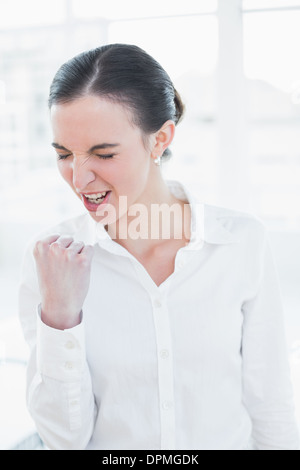 Cheerful businesswoman élégant cheering in office Banque D'Images