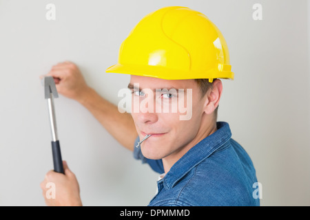 Close up of a handyman hammering nail à wall Banque D'Images