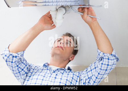 Plumber repairing vidange lavabo dans la salle de bains Banque D'Images