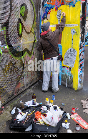 Londres, Angleterre, Royaume-Uni. Undercroft sous le Théâtre National sur la rive Sud - lieu de la planche à roulettes. Artiste Graffiti au travail Banque D'Images