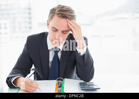 Inquiets businessman sitting at office desk Banque D'Images