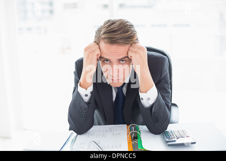 Portrait de peur businessman sitting at office desk Banque D'Images