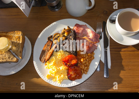 Le petit déjeuner anglais complet d'oeufs brouillés bacon champignons saucisse haricots, tomates frites et boudin noir servi au Yorkshire Banque D'Images
