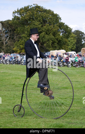 Man riding a penny farthing habillé dans des vêtements datant de l'époque victorienne jours Banque D'Images