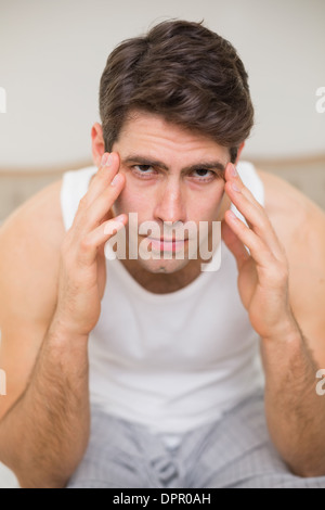 Portrait de l'homme souffrant de maux de tête au lit Banque D'Images