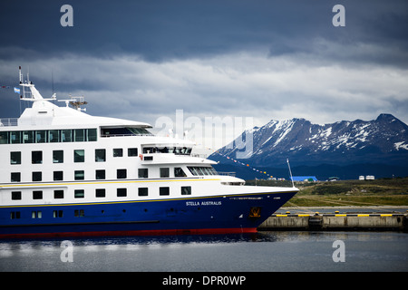 Le Stella australis, un navire de croisière exploité par Patagonia vacances qui tours sud du Chili et de la Patagonie, est amarré au port d'Ushuaïa à Ushuaia, Argentine. Les montagnes couvertes de neige dans la distance sont à travers le canal de Beagle au Chili. Banque D'Images