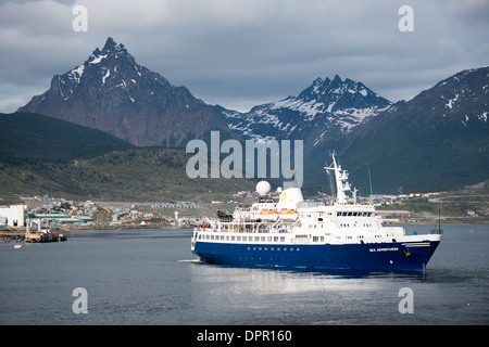 Navire d'expédition Sea Adventurer Monte Olivia Canal de Beagle Ushuaia Argentine | USHUAIA, Argentine — Le navire d'expédition Sea Adventurer, exploité par Quark Expeditions, se prépare à quitter le port d'Ushuaia avec les Andes Fuegiennes s'élevant abruptement en arrière-plan. Le pic triangulaire distinctif du Monte Olivia, atteignant 4 350 pieds (1 326 m), domine l'horizon montagneux au-dessus de la ville. Ushuaia est la principale porte d'entrée mondiale pour les croisières et expéditions en Antarctique, située à environ 621 milles (1 000 km) de la péninsule antarctique à travers le détroit de Drake, et le Sea Adventurer fait partie des navires renforcés pour les glaces Banque D'Images