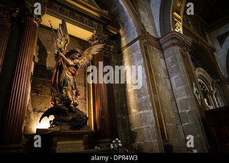 SANTIAGO, Chili — Une statue représentant Saint Georges tuant le dragon se trouve dans la cathédrale métropolitaine, représentant l'iconographie catholique traditionnelle. La pièce sculpturale, qui fait partie de la collection d'œuvres d'art religieux de la cathédrale, illustre la bataille légendaire entre le bien et le mal. Cette représentation artistique perpétue la tradition de la statuaire religieuse dans les églises catholiques chiliennes. Banque D'Images