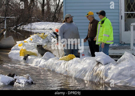 Mar 29, 2009 - Hendrum, Minnesota, USA - Hébergement VIRGIL MCKAY, à gauche, des entretiens avec Norman Comté MICK ingénieur ALM, centre, et Hendrum, Minn. fire CHEF PAUL LUOMA. McKay's home est entouré par les eaux de crue et de cinq pompes sont maintenant des fuites au bay. Bien que le niveau de la rivière Rouge est lentement tomber dans Fargo, S.D. et Moorhead, Minnesota, il continue d'augmenter au cours de 30 milles vers le nord en Hendru Banque D'Images