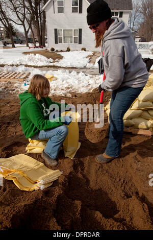 Mar 29, 2009 - Hendrum, Minnesota, USA - Ann TOMMERDAHL, droite, et sa fille Maria, TOMMERDAHL 12, remplissage de sacs de sable au milieu de la rue Main à Hendrum. Bien que le niveau de la rivière Rouge est lentement tomber dans Fargo, S.D. et Moorhead, Minnesota, il continue d'augmenter dans 30 milles au nord de Hendrum. Dimanche a commencé à Hendrum tranquille mais avant midi les niveaux d'eau dans la rivière Rouge a augmenté d Banque D'Images