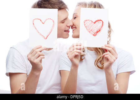 Portrait de jeune couple amoureux tout en maintenant les papiers avec des coeurs Banque D'Images