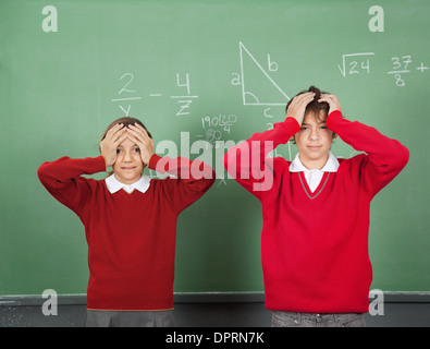 Confus Teenage Students Standing Bord Banque D'Images