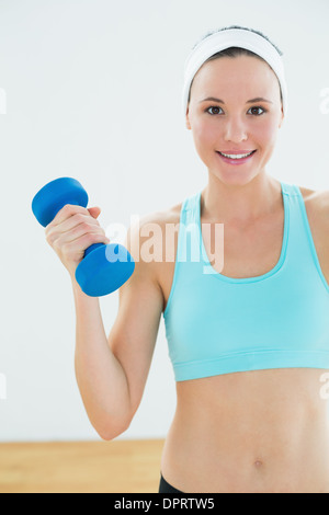 Portrait of a young woman holding dumbbells fit Banque D'Images