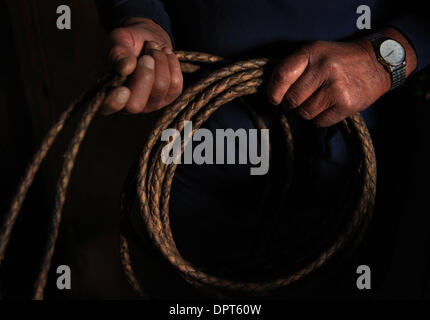 20 févr. 2009 - Waimea, Hawaii, États-Unis - Sonny Keakealani, l'un des plus respectés de cowboys dans la communauté et patriarche de la famille, tient sa Keakealani propose des lanières de cuir tressé dans sa selle et le cloue à l'abri de sa maison à Waimea, bonjour. Sonny a formé plusieurs jeunes cowboys au fil des ans et tout en maintenant officiellement pris sa retraite de Parker Ranch, fonctionne encore quelques jours un wee Banque D'Images