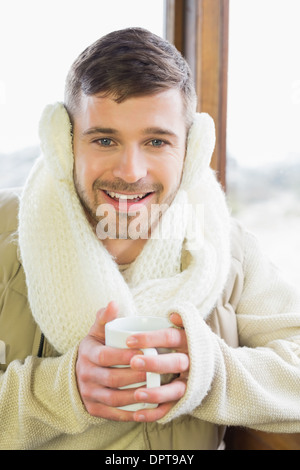 Smiling woman with coffee cup auditive protecteur d Banque D'Images