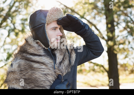 Jeune homme dans des vêtements chauds à l'écart dans la forêt Banque D'Images