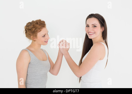 Portrait de deux jeunes femmes occasionnels friends Arm wrestling Banque D'Images