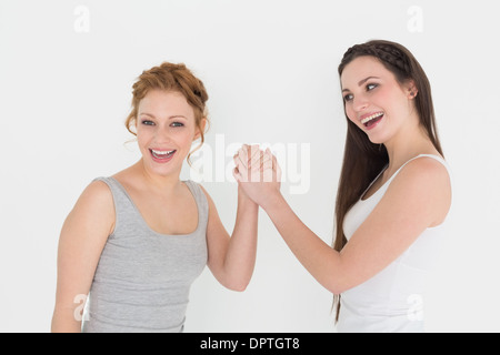 Portrait de deux jeunes femmes occasionnels friends Arm wrestling Banque D'Images