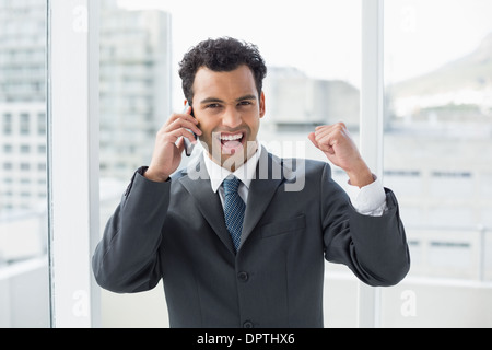 Élégante gaie young businessman using cellphone in office Banque D'Images