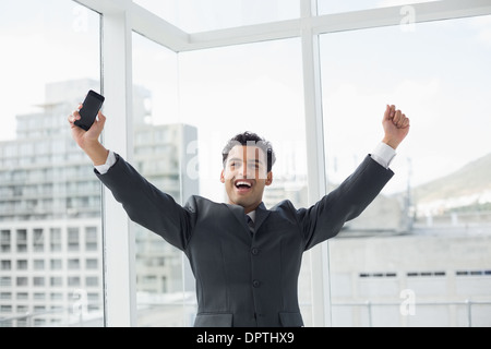 Jeune élégant businessman cheering in office Banque D'Images