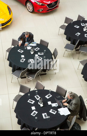Les professionnels de l'industrie automobile au travail avant une réunion de la Société des analystes de l'automobile. Banque D'Images