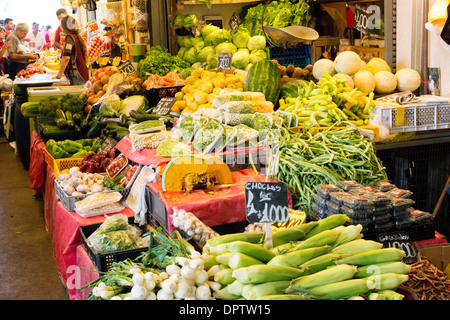 Mercado Tirso de Molina produits frais Choclo Winter Squash Santiago Chili / SANTIAGO, Chili — des produits frais, y compris le maïs, la courge et les légumes verts feuillus, remplissent les stands des vendeurs au Mercado Tirso de Molina, situé dans la commune de Recoleta à Santiago. L'installation sert de nœud de distribution vital reliant les consommateurs urbains à la production agricole de la fertile vallée centrale du Chili. Les stands présentent en bonne place des aliments de base régionaux, y compris le maïs féculent des Andes (*Zea mays*), connu localement sous le nom de choclo, et la courge d'hiver dense (*Cucurbita maxima*), qui prospèrent toutes deux dans le climat méditerranéen Banque D'Images